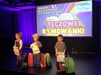 Troje dzieci pozuje do zdjęć z nagrodami