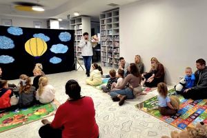 Dyrektor biblioteki wita dzieci na urodzinach pluszowego misia