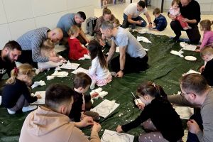 Tatusiowie z dziećmi wykonują bałwanki z waty