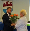 Burmistrz Miasta Jacek Kowalski przyjmuje gratulacje i kwiaty od radnej Krystyny Nasiadki.