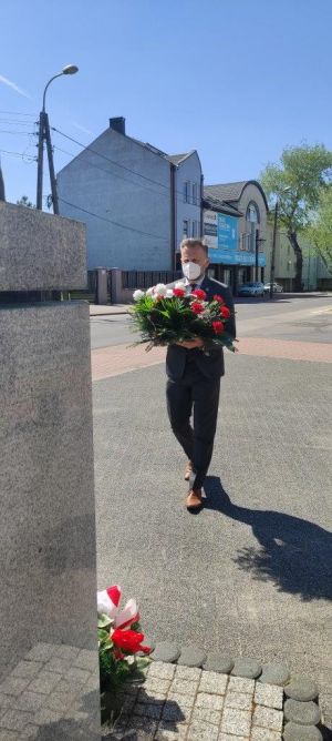 Jacek Kowalski niesie kwiaty pod pomnik Marszałka Piłsudskiego.