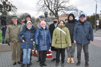 Grupa osób stojąca pod pomnikiem Marszałka Piłsudskiego