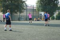 Piłkarze w niebieskich koszulkach grają z piłkarzami w różowych koszulkach.