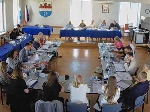 Kobiety i mężczyźni siedzący przy stole w kształcie podkowy.