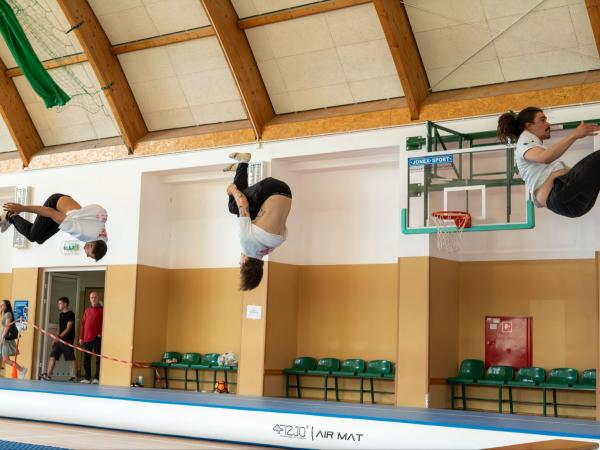 Trzech mężczyzn wykonujących jednocześnie salta.