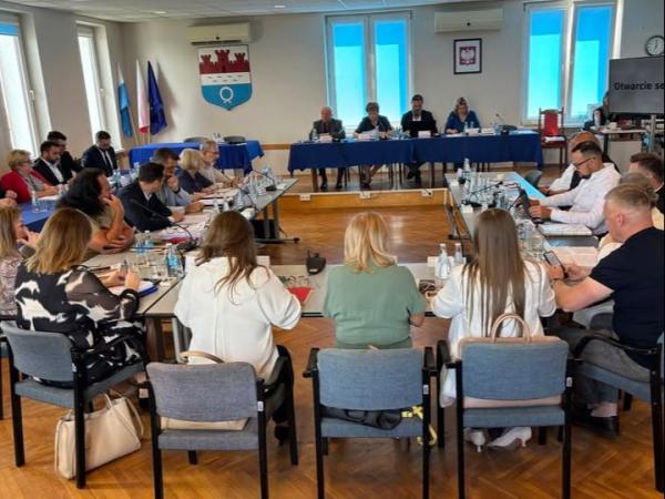 Kobiety i mężczyźni siedzący przy stołach.