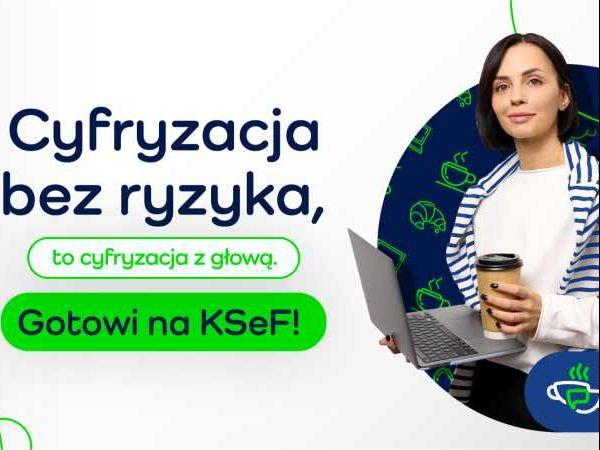 Kobieta trzymająca w prawym ręku laptop, w lewym kubek.