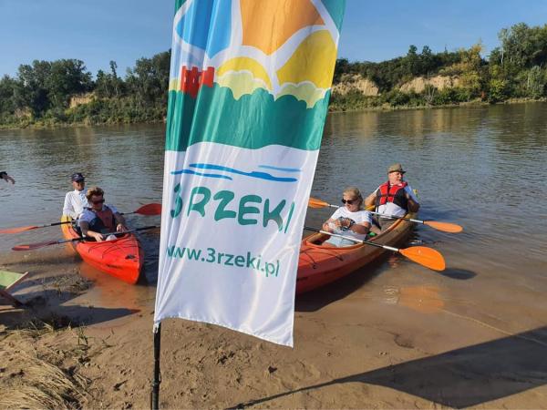 Flaga reklamowa 3 Rzeki. Dwa kajaki na wodzie z dwoma osobami w każdym.